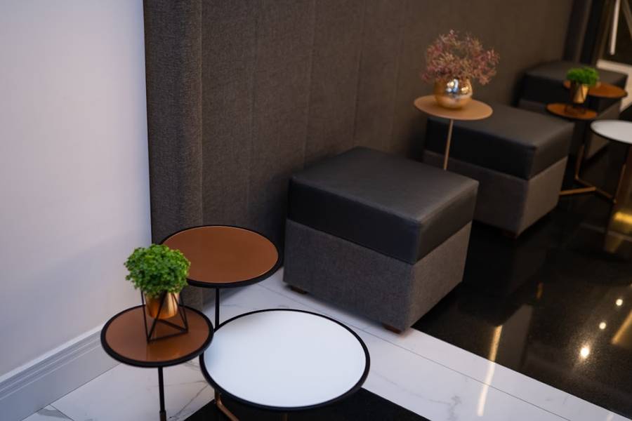 Espaço de estar com pufes, mesas de apoio e plantas